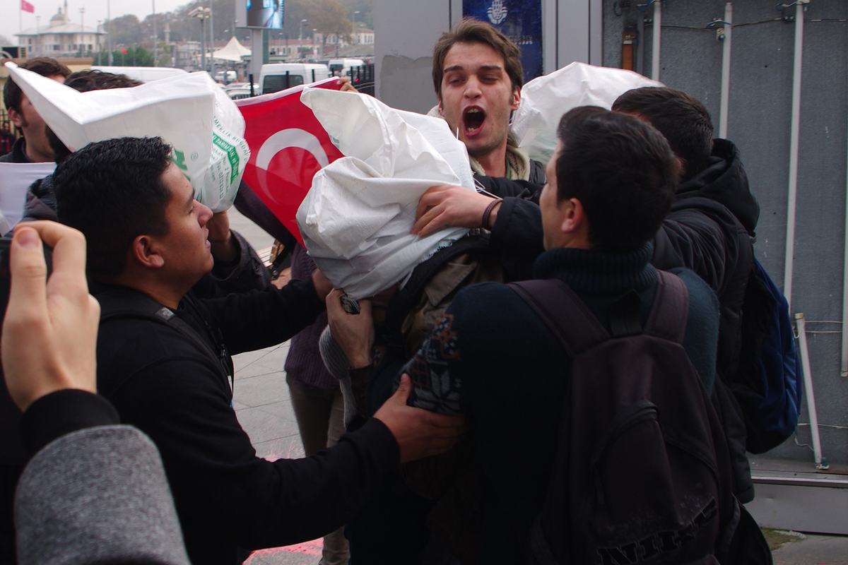Youth Union of Turkey members putting a sack over the head of a US sailor