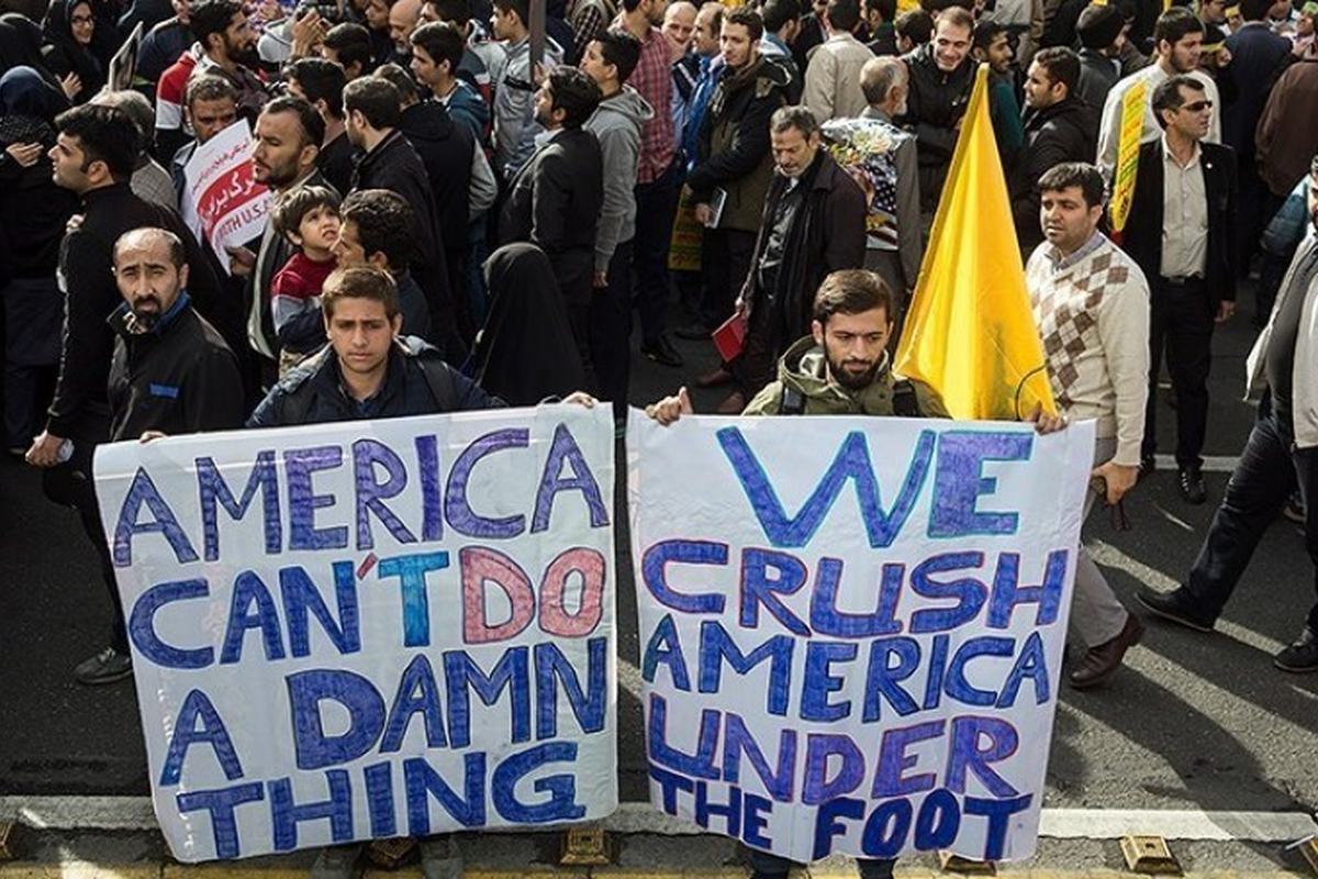 Iranianos em um ato com cartazes contra os Estados Unidos