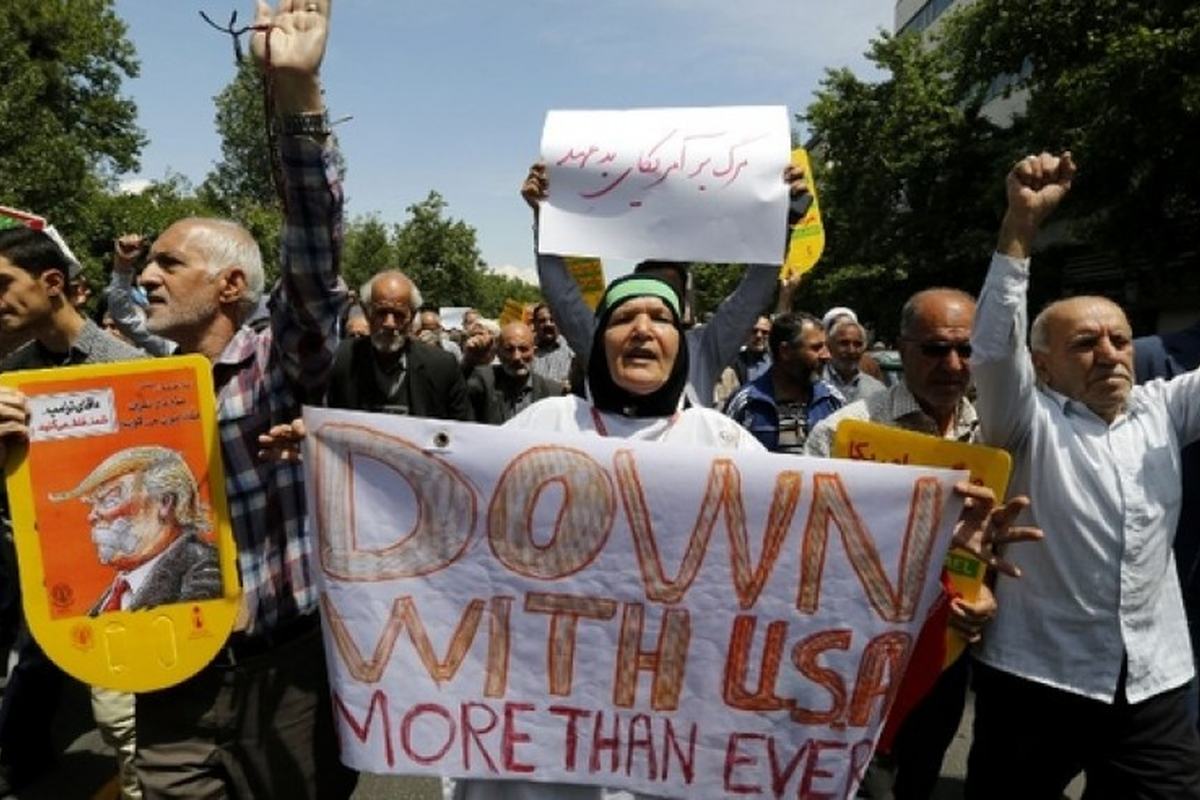 Manifestantes com uma faixa com os dizeres “Down with USA”