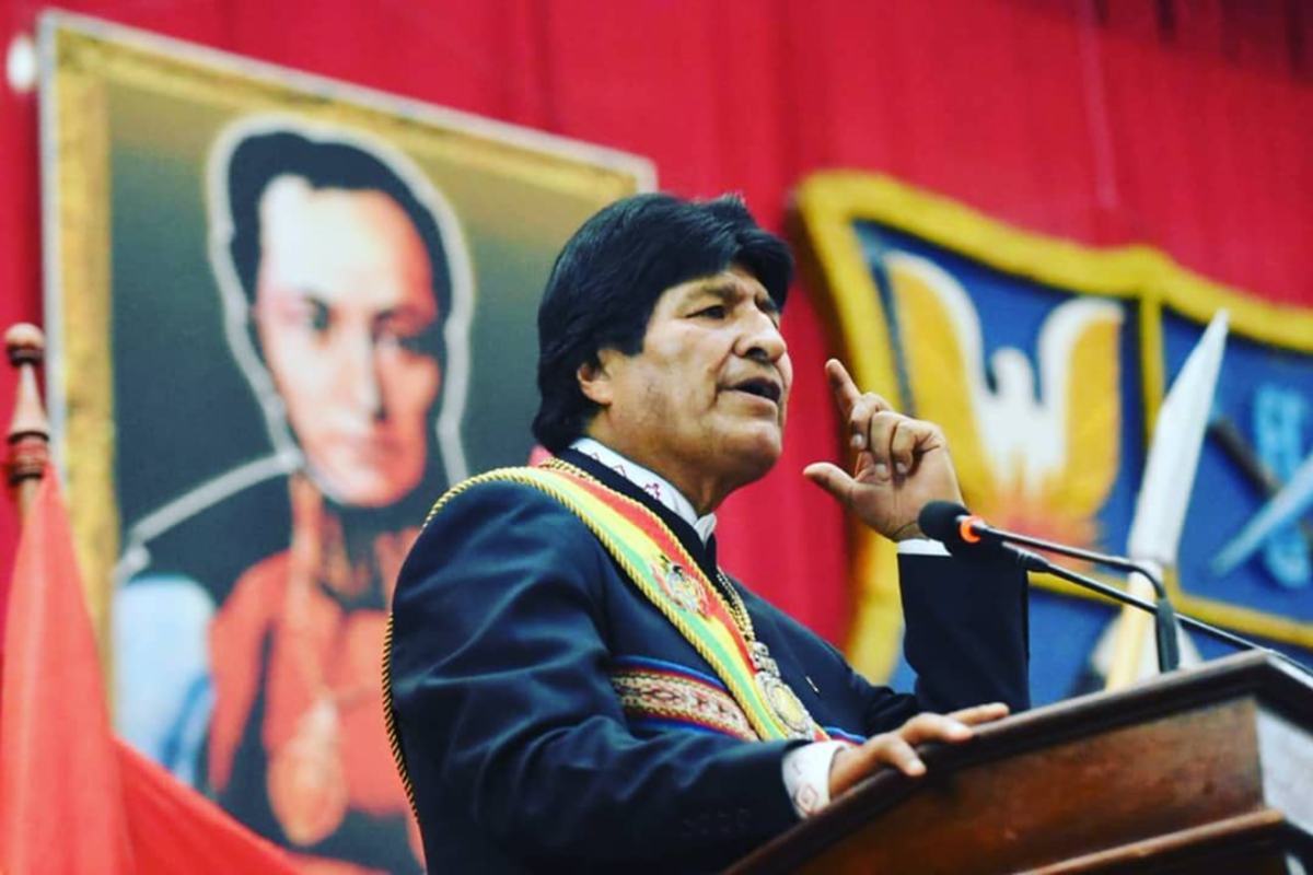 O presidente Evo Morales discursando diante de um retrato de Simón Bolívar