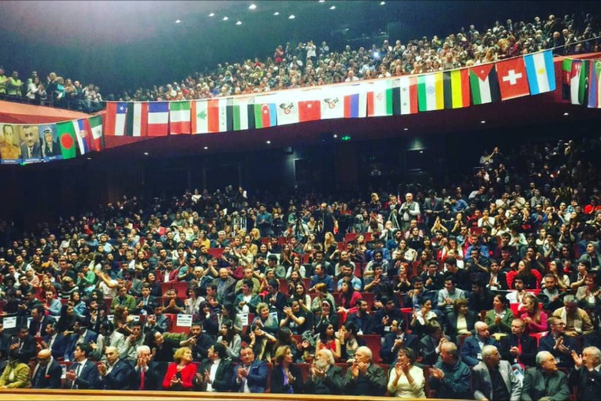 Um salão lotado sob as bandeiras de muitas nações em um congresso da WAYU
