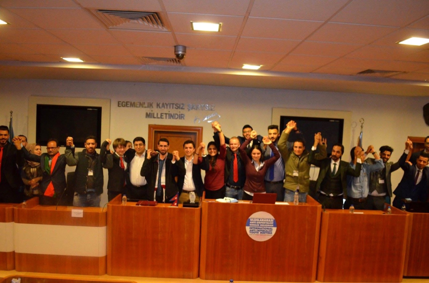 Young delegates raising their fists at the International Anti-Imperialist Youth Meeting, 2018